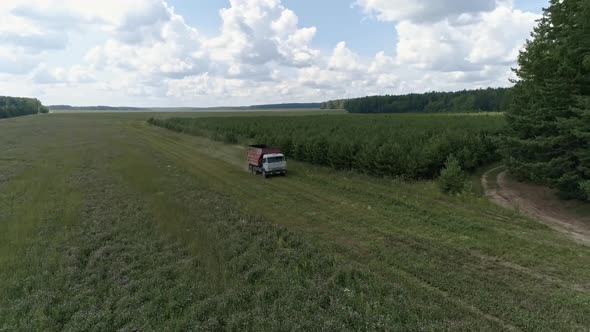 Aerial view of A truck is driving across the field and is approaching the harvesters 34 alt