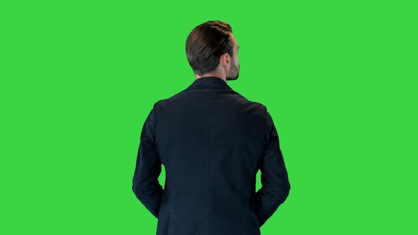 Confident Businessman Standing with Hands on Hips Looking Around on a Green Screen Chroma Key alt