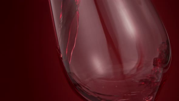 Pouring Red Wine in Super Slow Motion on Red Background alt