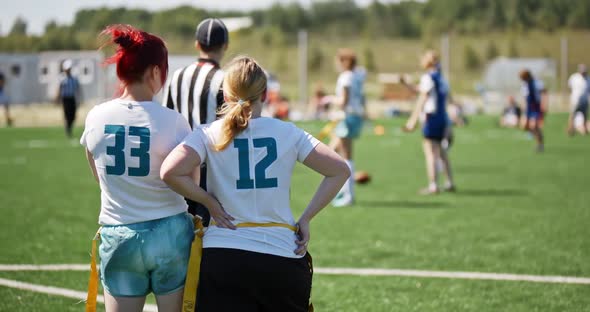 Silhouette of Women Watching the Game on the Green Grass in the Field. Athletic Female Team Playing alt