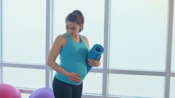 Closeup of a Pregnant Woman's Belly with a Sports Mat alt
