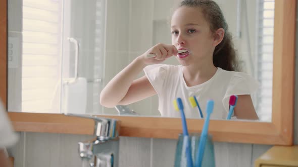 Portrait Happy Cute Young Teenage Girl Brushing Teeth in Bathroom and Smiling alt