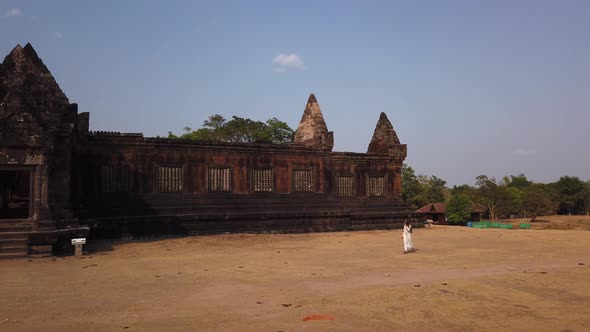 Lady walk near Khmer palace Vat Phou ruined Hindu Temple. Ancient architecture Champassak Laos Asia