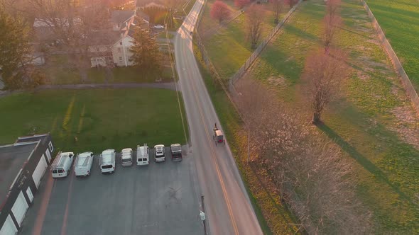 Aerial view of following a horse and buggy in late afternoon alt