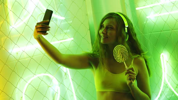 Lady Taking Selfie Against Neon Lights