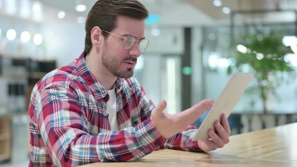 Disappointed Male Designer Reacting To Loss on Tablet alt