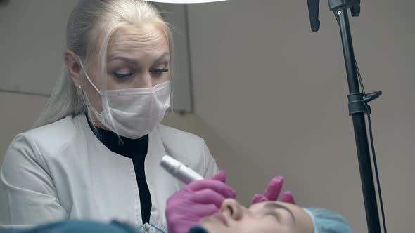 Cosmetology Specialist Applies Permanent Make-up and Nods alt