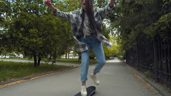 Teenage girl skateboarding in park alt
