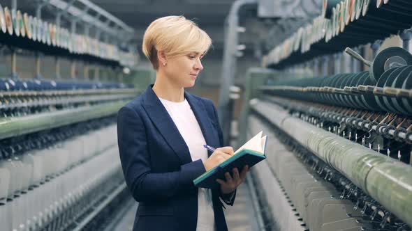 A Woman in a Business Suit is Taking Notes on the Sewing Equipment alt