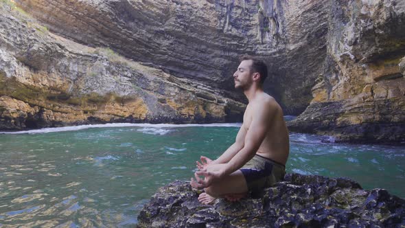 Muscular and attractive young man meditating. alt