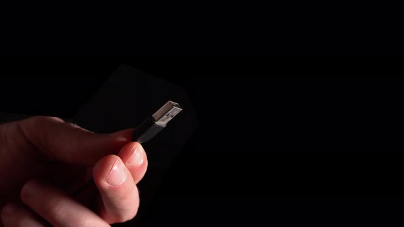 Usb Connector In Hand On Black Background
