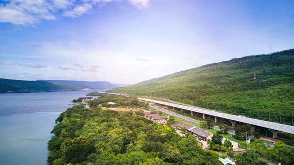 beautiful expressway in a green forest with a dam on the side of the road between mountains.