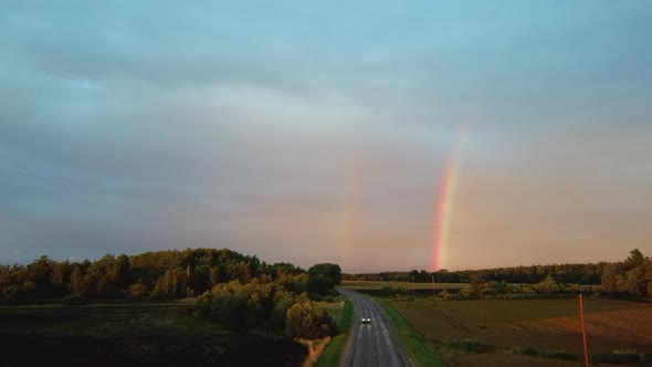 Dark Thunderstorm Clouds and Double Rainbow Over Forest and Wheat Field, Areal Dron Shoot. alt