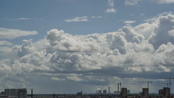 Clouds Quickly Fly and Rain Begins To Fall Over an Industrial Area of the City with Cranes Building