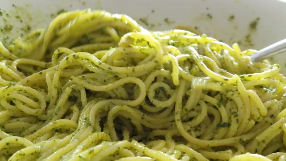 Spaghetti with Pesto Sauce Being Served with a Spaghetti Spoon alt