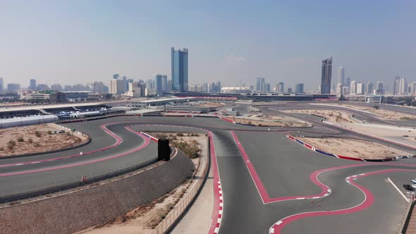 Aerial view of empty Dubai Autodrome race track, wavy corners, Dubai skyline