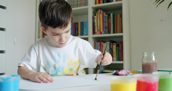 Boy Painting on Paper With His Left Hand