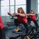 Group of Smiling Friends Women Class Exercising Training Spinning on Stationary Bike at Modern Gym - VideoHive Item for Sale