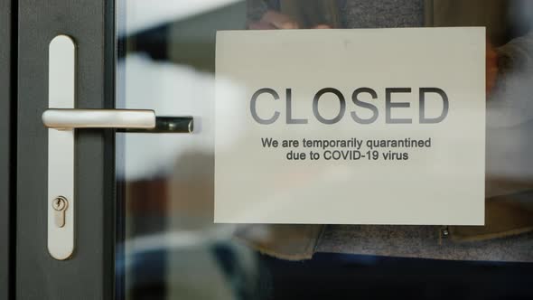 Business Owner Hangs on Door Announcement of Closure Due to Coronavirus Quarantine alt