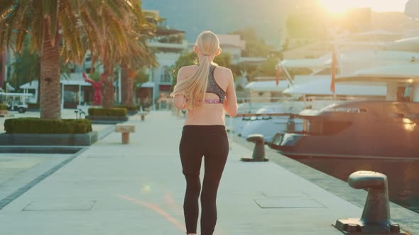 Blonde Woman Jogging in Southern Country in the Rays of Morning Sun