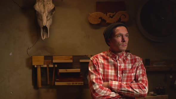Portrait of Young Attractive Man Carpenter in Plaid Shirt Resting in Craftshop After Making Wood alt