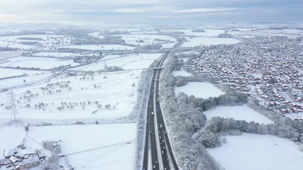 Aerial view of snow covered countryside and highway road