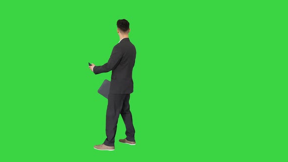 Young Business Man Walking and Taking a Selfie on a Green Screen, Chroma Key. alt