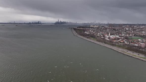 A high angle, aerial view over Upper Bay in Brooklyn NY. The drone camera dolly in and pan left towa alt