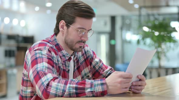 Male Designer with Documents Reacting To Loss, Failure  alt