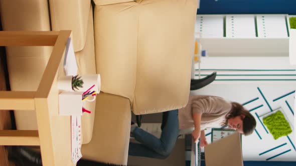 Focused Black Manager Reading Tasks on Laptop and Typing Sitting on Couch alt