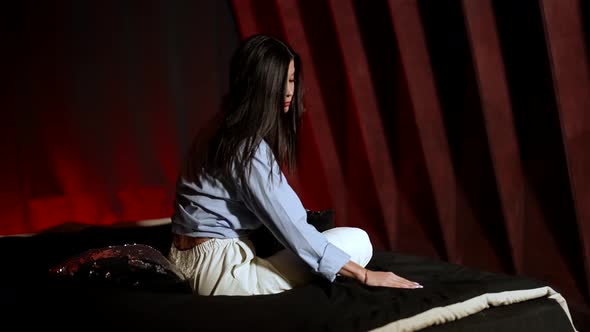 Lonley Brunette Woman is Sitting in Her Bedroom at Night Embracing Her Shoulders and Boring Alone alt