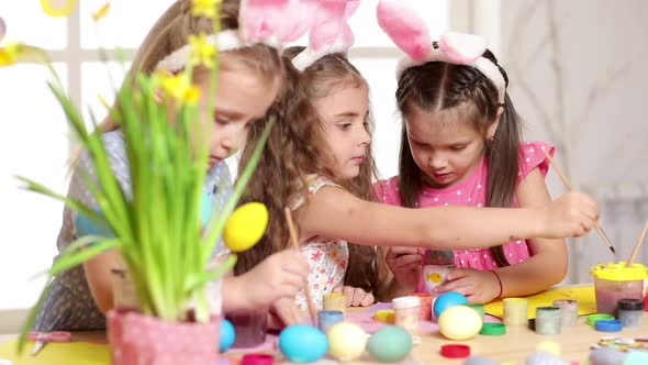 Happy Children Wearing Bunny Ears Painting Eggs on Easter Day