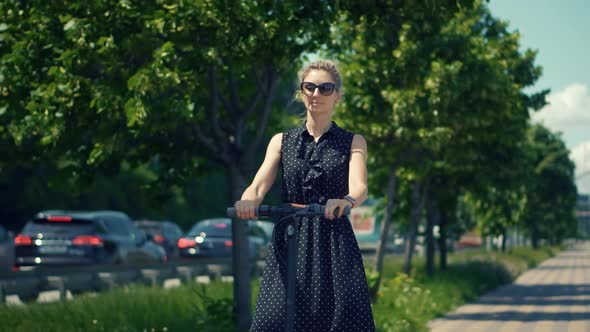 Scooter.Electric Scooter.Eco Transport Scooter.Woman Taking Electronic Scooter Share.E-Scooter alt