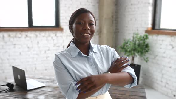 Highskilled AfricanAmerican Businesswoman Wearing Smart Casual Shirt Stands with Arms Crossed
