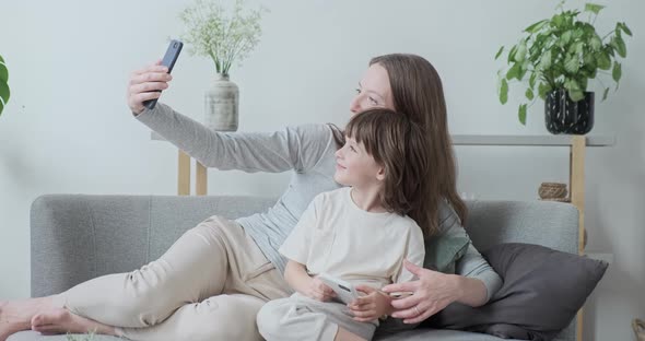 Modern Woman Babysitter and Kid Boy Posing Hugging Together Taking Photo Use Smartphone alt