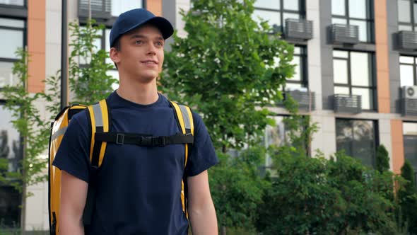 Smiling Delivery Man Courier with Thermal Backpack Walks Street Deliver Order alt