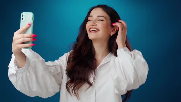 Happy Positive Woman Having Video Call on Smartphone Against Blue Background