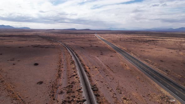 Drone shot of a railroad and highway in the desert of New Mexico alt