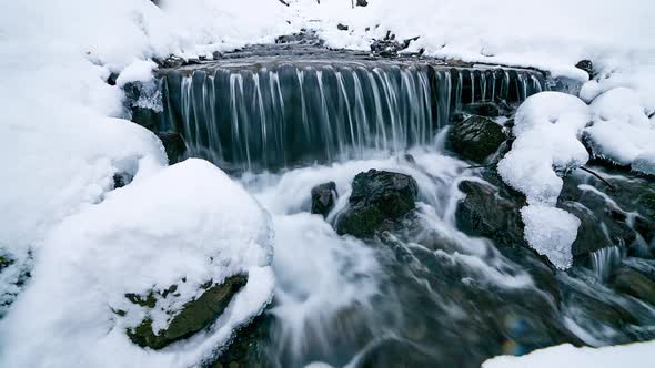 River Water Flows Between the Ice and Snow in the Mountains Natural Pure Pristine Water Video