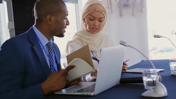 Two delegates talking making notes at a business conference alt