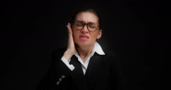 Business Woman in Glasses and Business Clothes Has a Sharp Pain in Her Ear alt