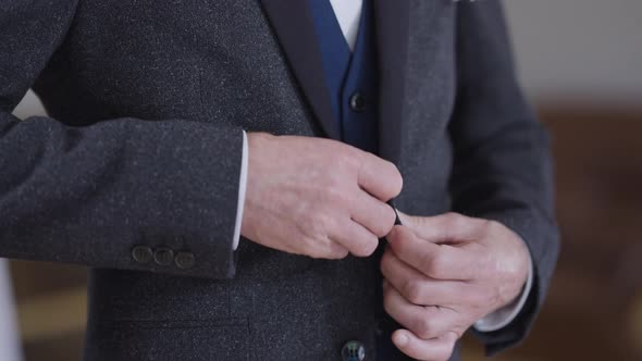 Senior Male Hands Buttoning Wedding Blazer with Boutonniere in Slow Motion alt