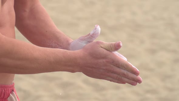 Young man prepares to swing on the Santa Monica traveling rings. alt