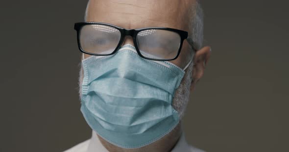 Senior man with glasses fogging up while wearing a protective face mask