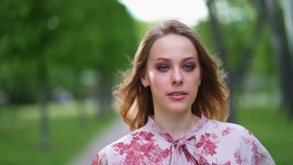 Attractive Young Woman with Smoky Eyes Make Up Look at Camera Smile Stand in the City Park Slow alt