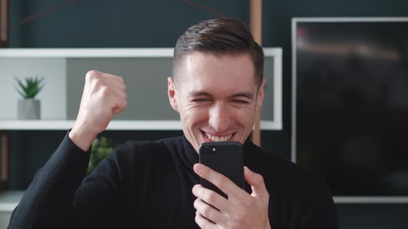 Excited Business Man Winner Celebrating Success Hold Smartphone Feel Amazed Overjoyed with Mobile
