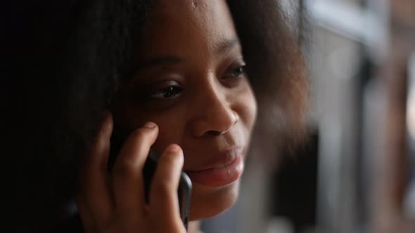 Closeup Face of Pretty Laughing AfricanAmerican Woman Talking on Mobile Phone with Friend Boyfriend