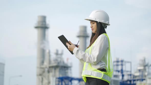 Industrial engineer using digital tablet for work against the background of electrical power plant.