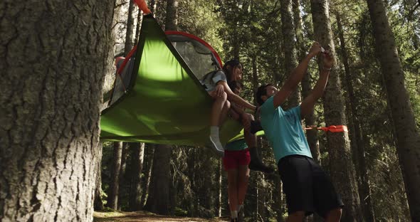 Man Making Smartphone Selfie with Smiling Woman on Hanging Tent Camping in Sunny Forest