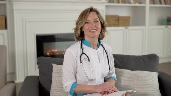 Happy Female Doctor Giving Online Consultation to Patient Through Video Conference on Laptop alt